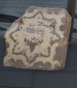 Floor tile depicting a lion, or possibily the sun?