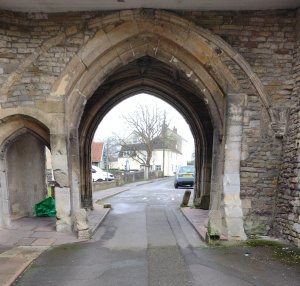 Archway with cars and recycling sacks- an ancient building with modern life around it!